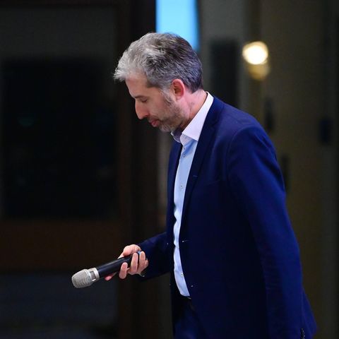 Boris Palmer senkt den Kopf und hält ein Mikro in der Hand