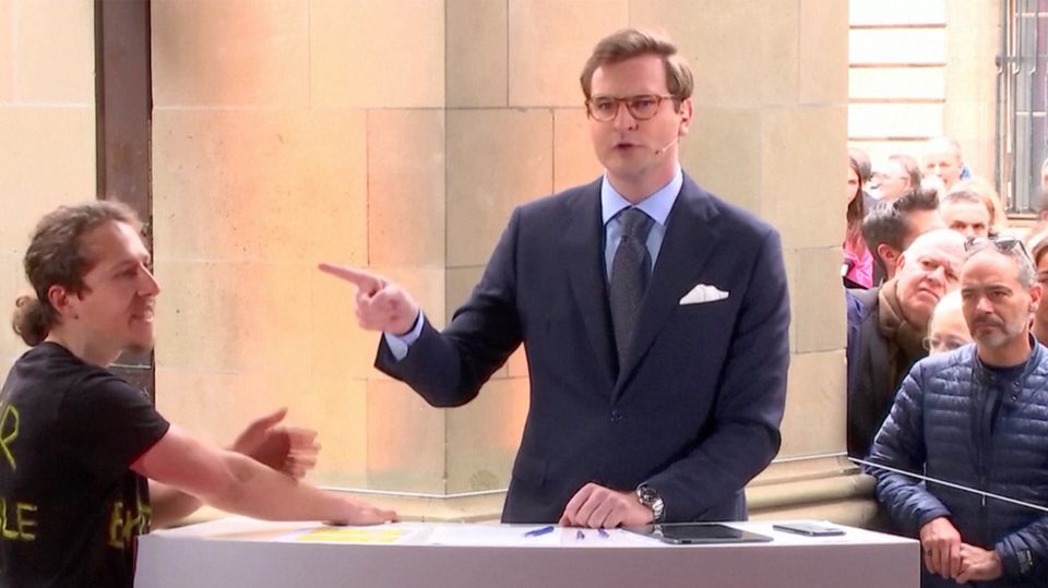 Klimaprotest: Aktivist klebt sich bei Live-Sendung an Pult – Moderator reagiert ungehalten Klimaprotest: Aktivist klebt sich bei Live-Sendung an Pult – Moderator reagiert ungehalten