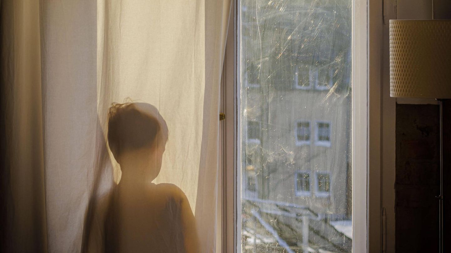 Kindergrundsicherung Kind steht am Fenster und schaut hinaus