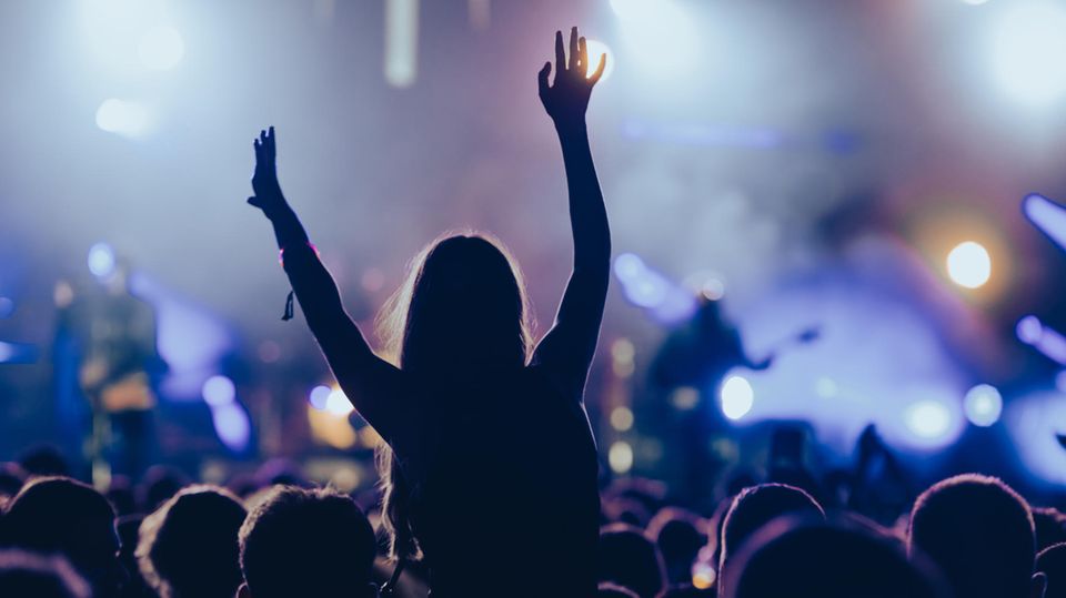 Publikum steht vor der Bühne bei einem Konzert.
