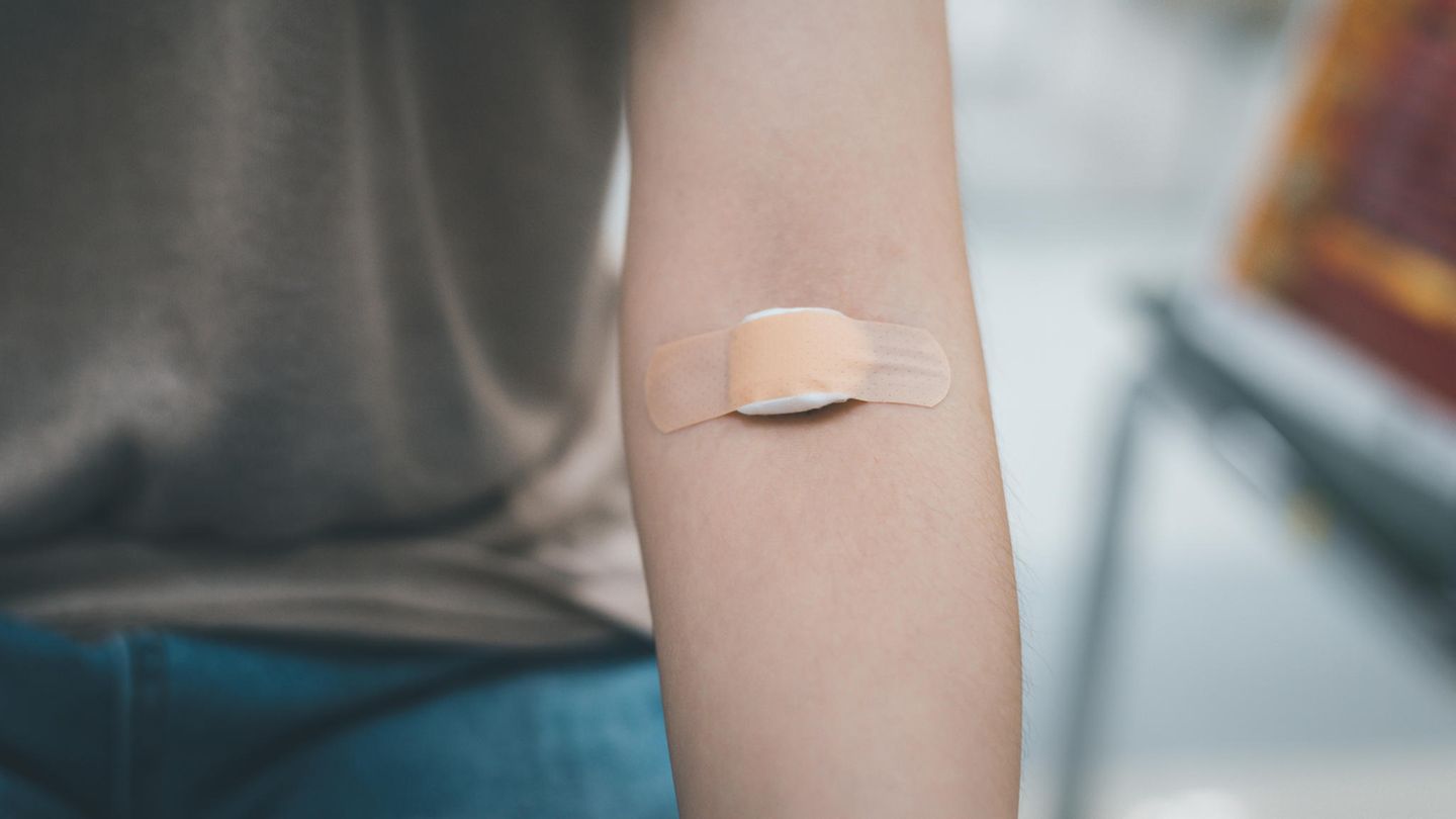Arm mit Pflaster nach Blutabnahme Arm mit Pflaster nach Blutabnahme