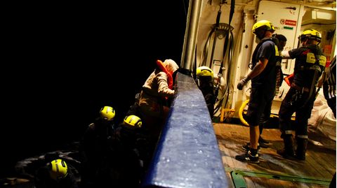Migranten gehen an Bord eines Seenotrettungsschiffes