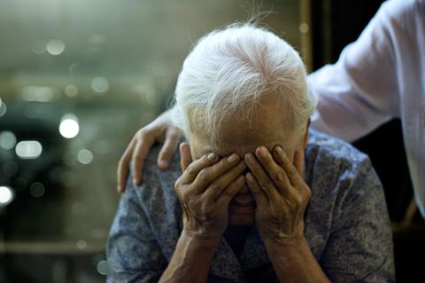 Ältere Frau hält sich verzweifelt die Hände vors Gesicht