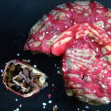 Rocciata (Umbrischer Strudelkuchen mit Obst, Nüssen und Anislikör)  Für 1 Kuchen  Zubereitungszeit 40 Minuten, plus Ruhezeit 30 Minuten, plus Backzeit 40 Minuten      Zutaten:  Für den Teig:  - 300 g Mehl (Tipo 00 oder Type 405)  - 1 Prise Salz 1 EL Zucker 2 EL Olivenöl 20 ml Weißwein 1 Ei (Größe L)  Für die Füllung:  - je 100 g Rosinen und getrocknete Aprikosen  - 700 g süßsaure Äpfel  - je 50 g Mandel- und Walnusskerne  - 30 g Pinienkerne  - 1 Pck. Bourbon-Vanillezucker  - 1 gestrichener EL Zimt  - 70 g Zucker  - 2 EL Anislikör (beispielsweise Mistrà oder Weißwein)  - 2 EL Olivenöl 1 Prise Salz 1 EL Zitronenabrieb 1 EL Orangenabrieb  Zum Bestreichen:  - je 1 EL Zucker und Hagelzucker  - 1 EL Olivenöl  - 50 g Puderzucker  - 15 ml Alkermes (italienischer Kräuterlikör) oder Grenadinesirup      Zubereitung:  1. Alle Zutaten für den Teig mit 70 ml lauwarmem Wasser gut verkneten. Den Teig in Frischhaltefolie wickeln und für 30 Minuten in den Kühlschrank legen.  2. Die Rosinen und die Aprikosen mit heißem Wasser übergießen und 5–8 Minuten einweichen. Das Wasser abgießen und das Restwasser gut auspressen. Die Äpfel schälen, vierteln, vom Kerngehäuse befreien und in Stücke schneiden.  3. Die Mandeln und Walnüsse grob hacken. Sämtliche Zutaten für die Füllung vermischen und 30 Minuten ziehen lassen.  4. Den Backofen auf 180 °C vorheizen. Ein Blech mit Backpapier belegen. Den Teig auf einer bemehlten Fläche so dünn wie möglich zu einem länglichen Rechteck ausrollen. Die Füllung gleichmäßig darauf verteilen, rundherum einen 2 cm breiten Rand frei lassen. Die kurzen Seiten etwas über die Füllung legen, dann den Teig von der langen Seite her aufrollen. Die Naht mit Wasser befeuchten, damit sie gut zusammenklebt. Die Rolle zu einem Ring formen und auf das Blech legen. 1 EL Zucker mit 1 EL Olivenöl vermischen, den Teig damit bestreichen und 40 Minuten im Ofen backen.  5. Den Kuchen abkühlen lassen. Den Puderzucker mit dem Alkermes oder Sirup dickflüssig verrühren, über den Kuchen gießen und mit dem Hagelzucker bestreuen.