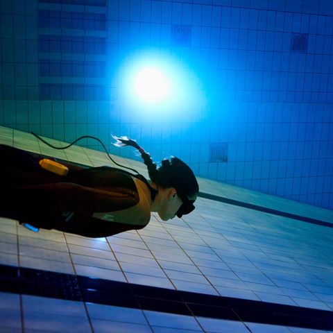 Apnoe Taucherin schwimmt am Boden eines Schwimmbades