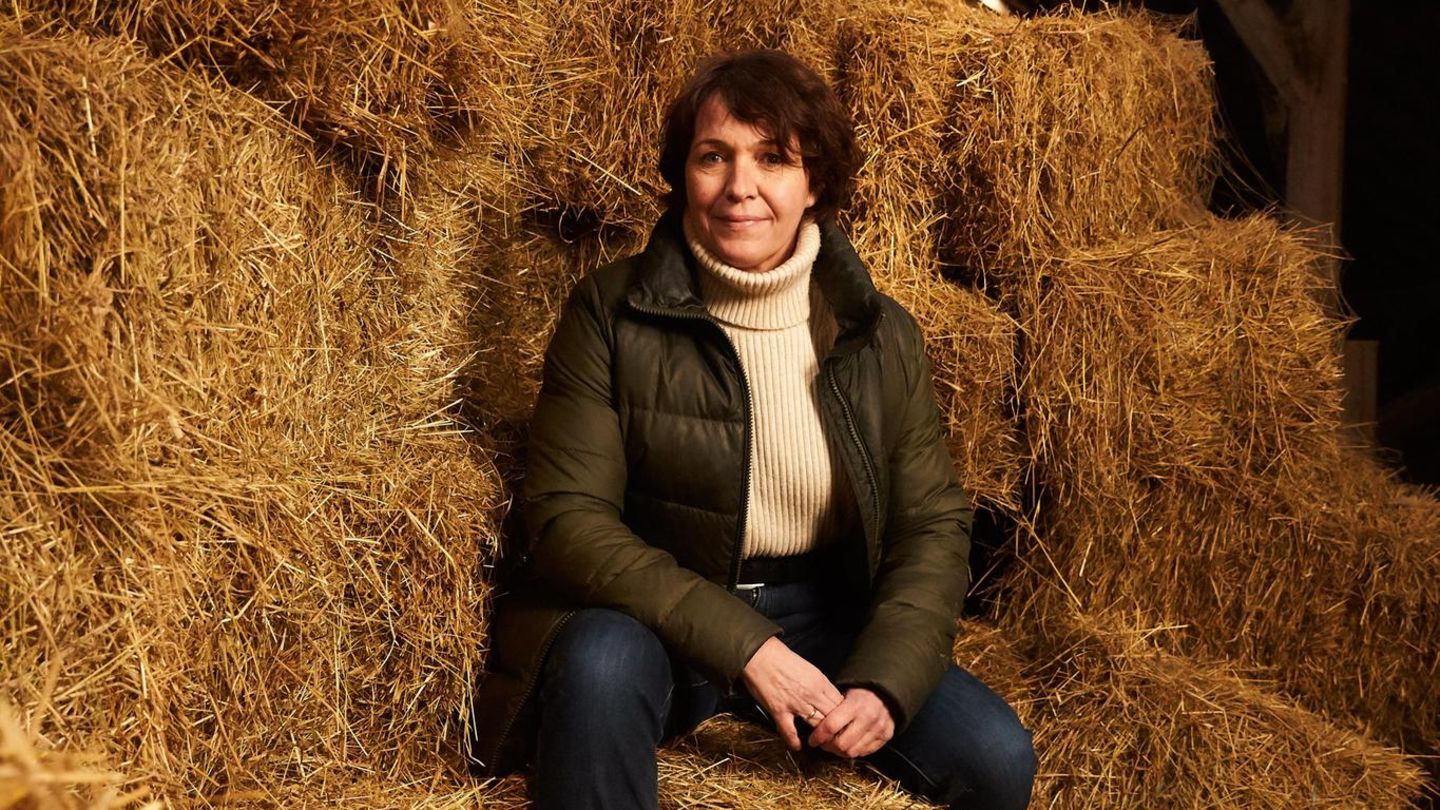 Eine Frau sitzt auf einem Haufen Heuballen