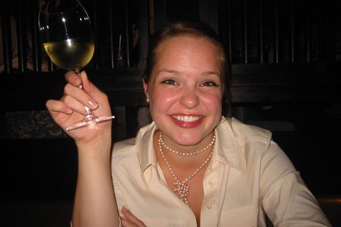 Junge Frau mit einem Glas Weißwein in der Hand