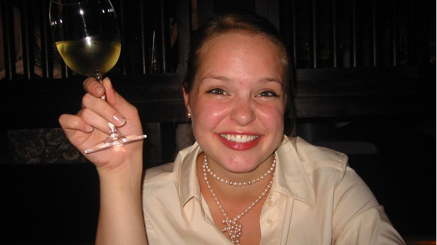 Junge Frau mit einem Glas Weißwein in der Hand