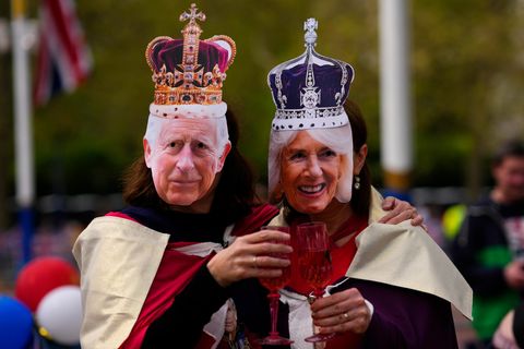 Zwei Royal-Fans posieren mit Masken, die König Charles III. von Großbritannien und Königsgemahlin Camilla darstellen