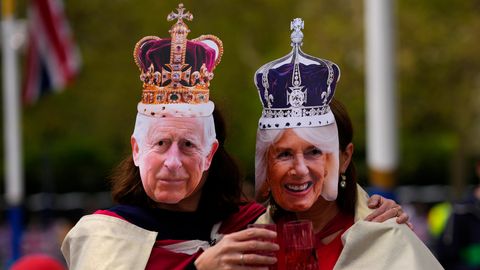 Zwei Royal-Fans posieren mit Masken, die König Charles III. von Großbritannien und Königsgemahlin Camilla darstellen