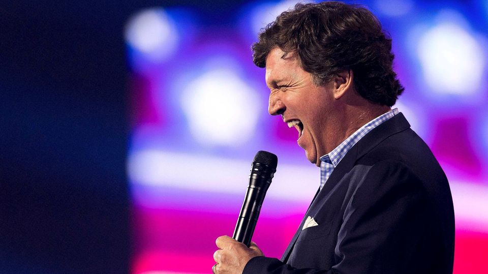 Der ehemalige Fox-News-Moderator Tucker Carlson spricht inbrünstig in ein Mikro
