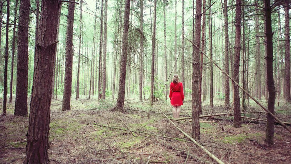 Frau steht im Wald