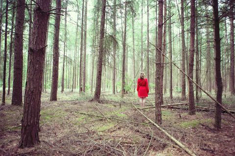 Frau steht im Wald