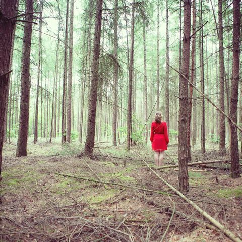 Frau steht im Wald