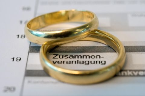 Zwei goldene Eheringe liegen auf einem Formular einer Steuererklärung