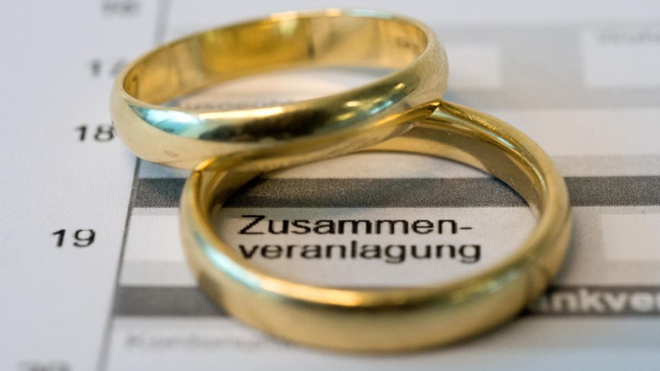 Zwei goldene Eheringe liegen auf einem Formular einer Steuererklärung