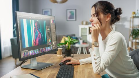 Eine Frau bearbeitet ein Foto auf einem 5K-Monitor