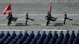 Soldaten tragen die Fahnen der Russischen Föderation und der zerfallenen Sowjetunion über den Roten Platz. 