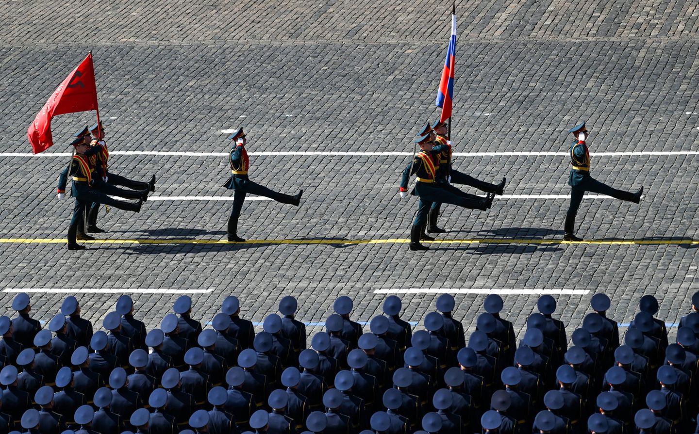 Soldaten tragen die Fahnen der Russischen Föderation und der zerfallenen Sowjetunion über den Roten Platz. 