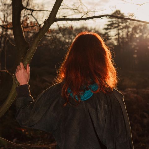 Eine Frau schaut in den Sonnenuntergang