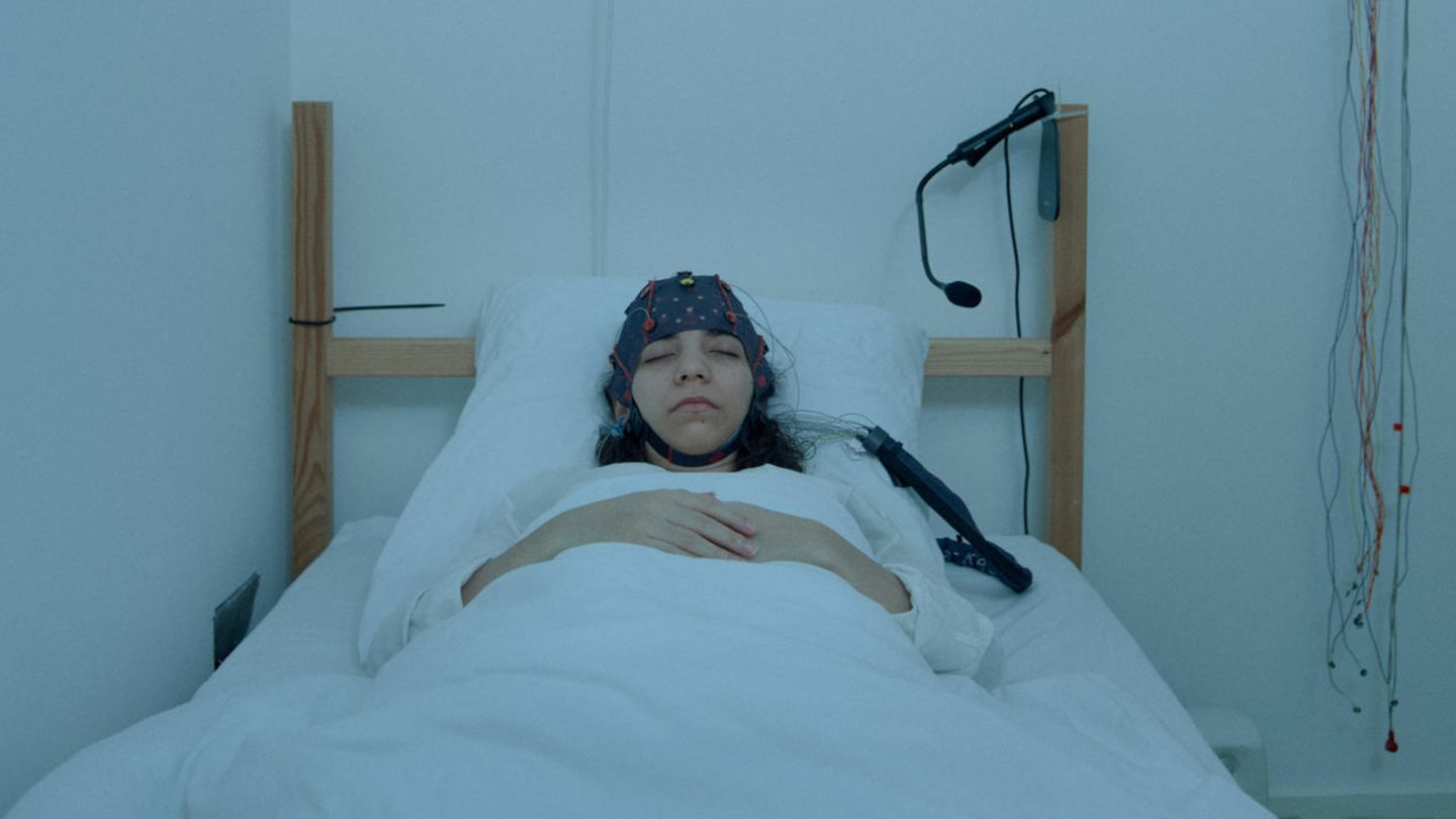 Frau schläft im Labor mit Elektodenhaube