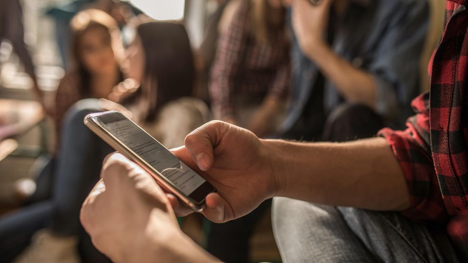 Ein Schüler hält ein Smartphone in der Hand: Rechtsextremismus an Schulen äußert sich auch im Klassen-Chat