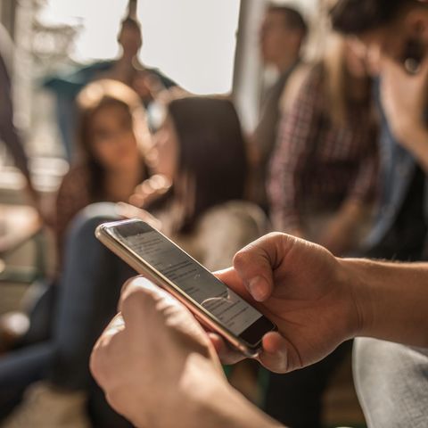 Ein Schüler hält ein Smartphone in der Hand: Rechtsextremismus an Schulen äußert sich auch im Klassen-Chat