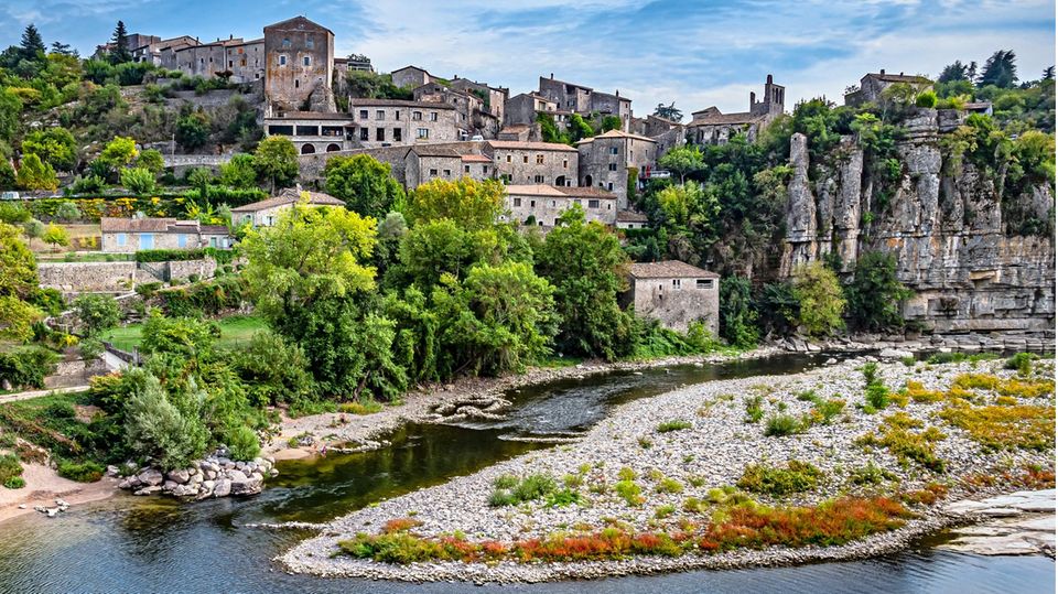 Flussmündung und im Hintergrund auf einer Anhebung kleines steinernes Dorf