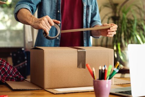 Ein Mann verpackt ein Paket und bereitet einen Betrug vor