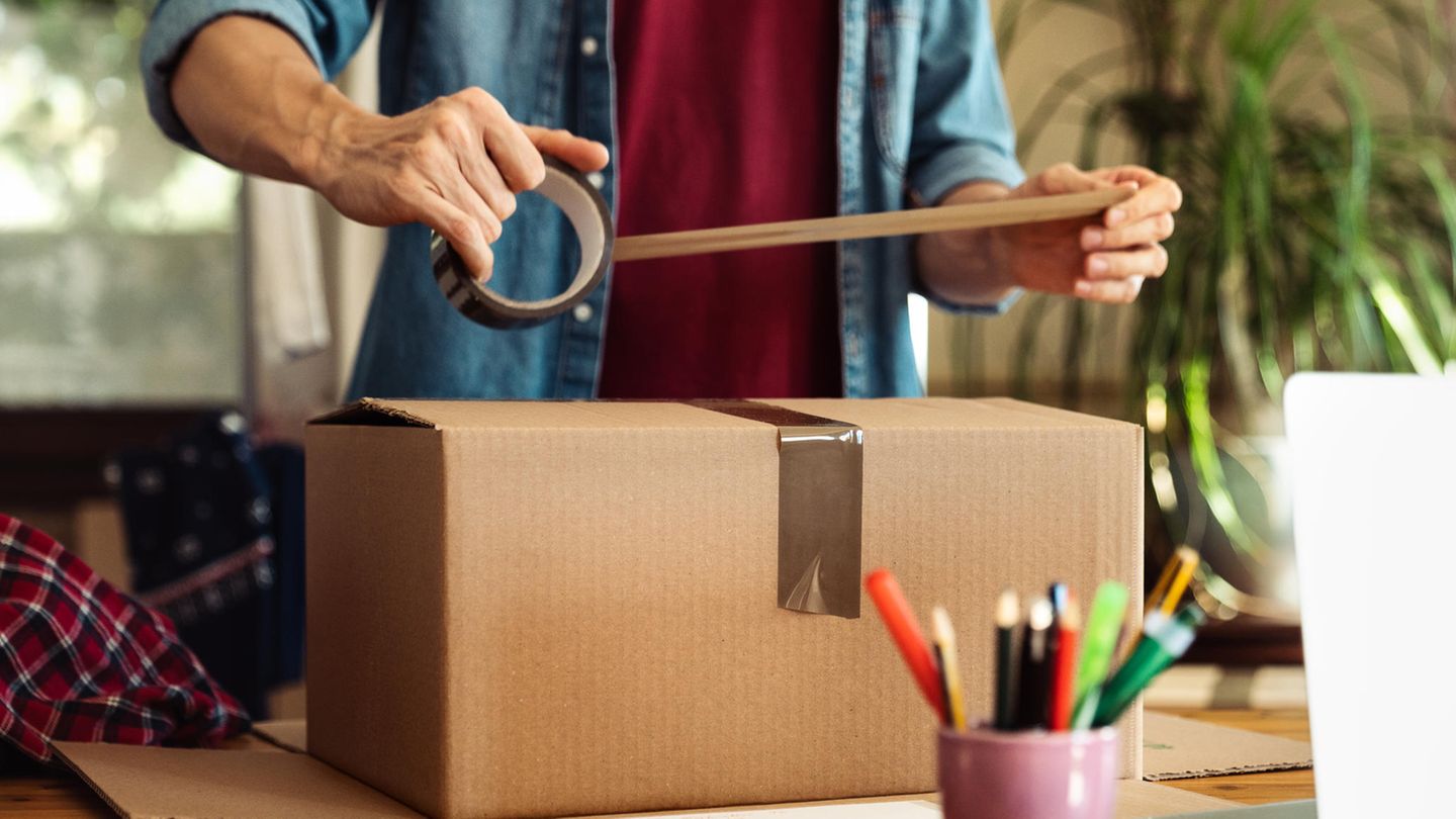 Ein Mann verpackt ein Paket und bereitet einen Betrug vor Ein Mann verpackt ein Paket und bereitet einen Betrug vor