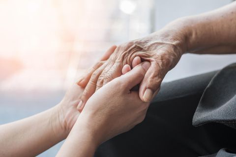 Zwei Menschen halten sich an den Händen. Death Doulas begleiten Sterbende in den Tod.