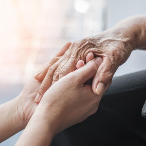 Zwei Menschen halten sich an den Händen. Death Doulas begleiten Sterbende in den Tod.