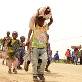 Kongolesische Flüchtlinge tragen ihre Sachen über die Grenze von Uganda