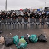 Venezolanische Migranten blockieren die Grenze mit Müll vor einer Barrikade der peruanischen Polizei