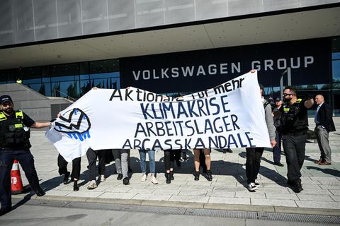 Aktivisten protestieren mit einem Banner vor dem Gebäude der VW-Hauptversammlung