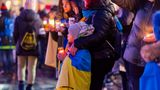 Solidaritätskundgebung für die Ukraine in Dresden – Menschen halten Flaggen und Kerzen in den Händen