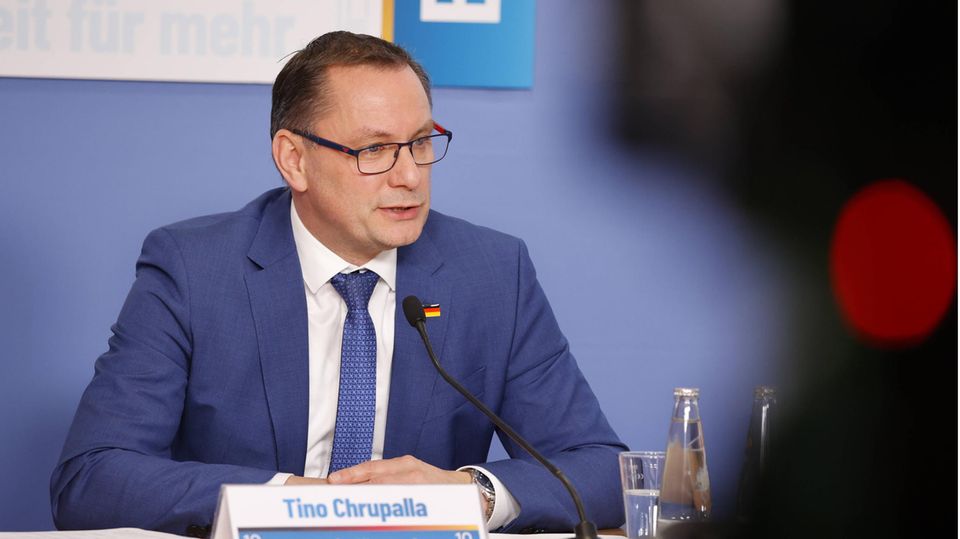 Tino Chrupalla sitzt vor einem Mikrofon