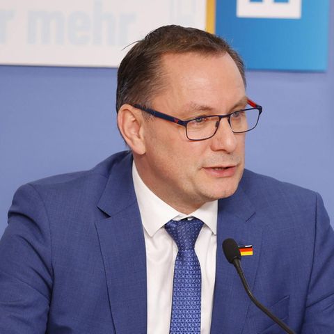 Tino Chrupalla sitzt vor einem Mikrofon