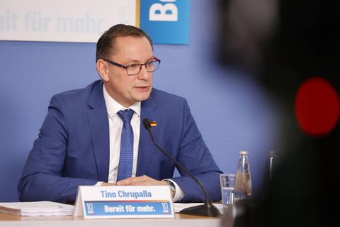 Tino Chrupalla sitzt vor einem Mikrofon
