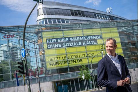 Mario Czaja vor dem Konrad-Adenauer-Haus mit einem Schild: Für eine Wärmewende ohne soziale Kälte