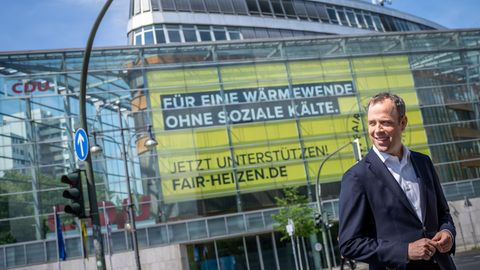 Mario Czaja vor dem Konrad-Adenauer-Haus mit einem Schild: Für eine Wärmewende ohne soziale Kälte