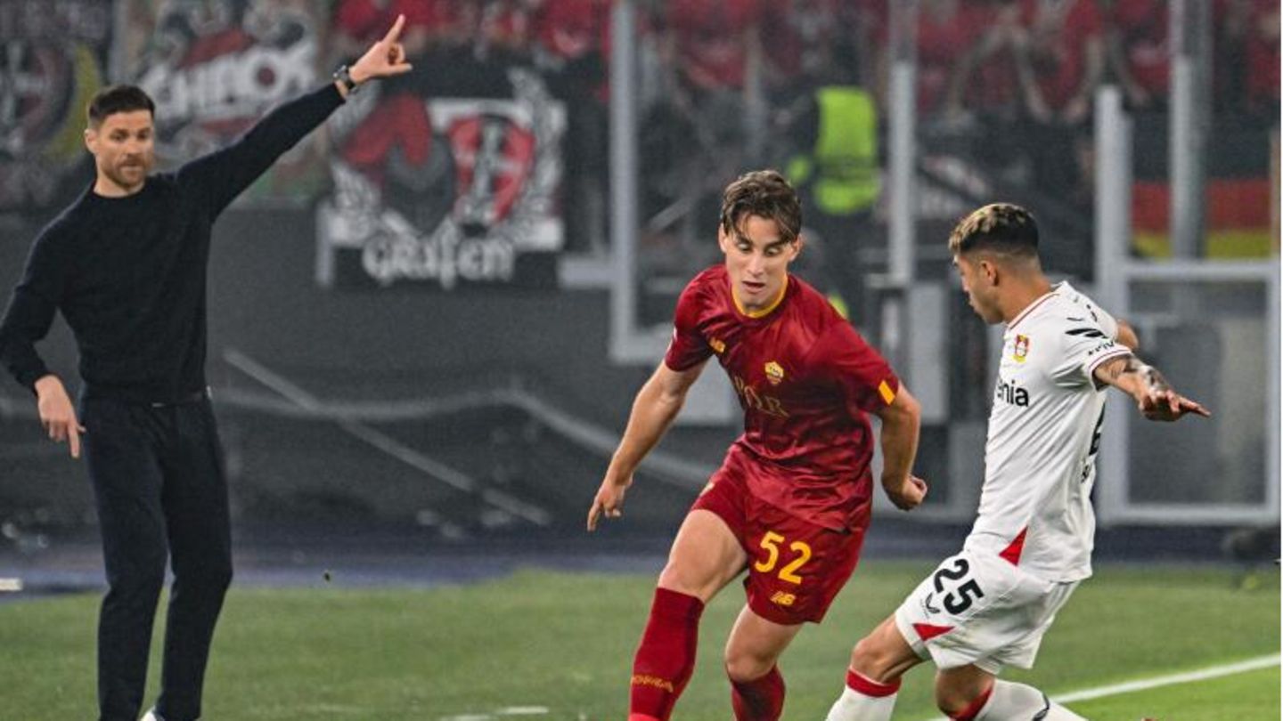 Alonso gestikuliert, während Bove (Mitte) von AS Roma mit Leverkusens Palacios (rechts) um den Ball kämpft