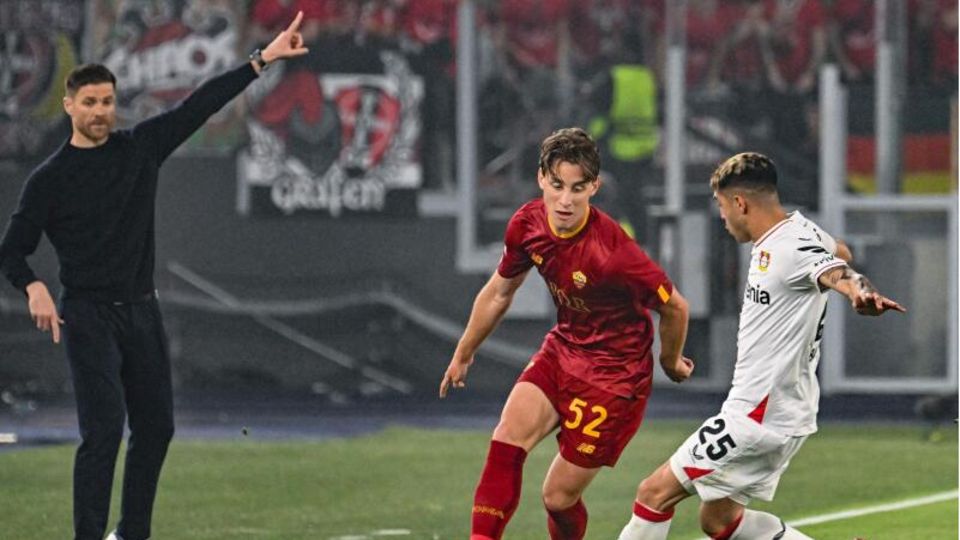 Alonso gestikuliert, während Bove (Mitte) von AS Roma mit Leverkusens Palacios (rechts) um den Ball kämpft