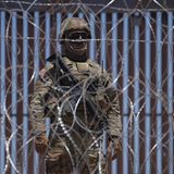 Auf der anderen Seite stehen schwerbewaffnete Sicherheitskräfte Wache