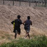 Zwei junge Migranten aus Venezuela laufen bei Ciudad Juarez in Mexiko den Rio Bravo entlang, in der Hoffnung, über den Stacheldrahtzaun in die USA zu gelangen.