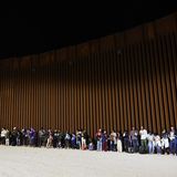 Unüberwindbar wirkt der Zaun: Asylsuchende, die noch vor dem Auslaufen von Titel 42 in Yuma, im US-Bundesstaat Arizona von US-Grenzschützern aufgegriffen wurden, warten darauf, wie es mit ihnen weitergeht.