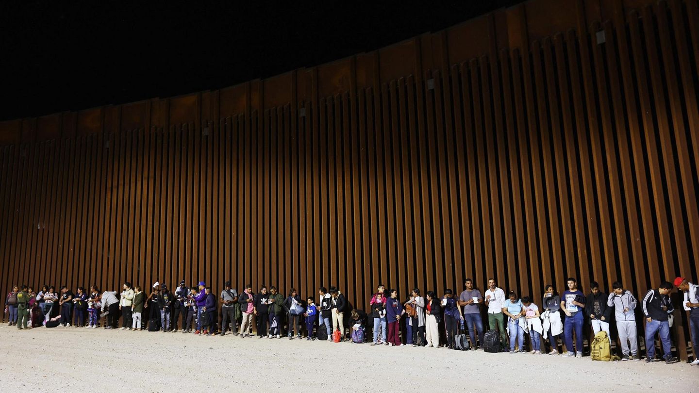 Unüberwindbar wirkt der Zaun: Asylsuchende, die noch vor dem Auslaufen von Titel 42 in Yuma, im US-Bundesstaat Arizona von US-Grenzschützern aufgegriffen wurden, warten darauf, wie es mit ihnen weitergeht.