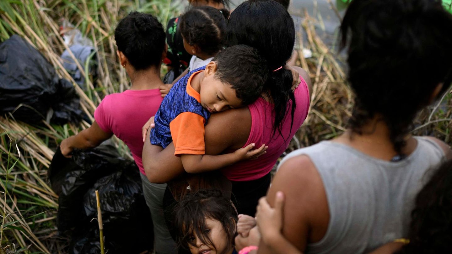 Migranten aus Mittel- und Südamerika: Erschöpft ist ein Kind auf dem Arm seiner Mutter eingeschlafen, während sie in der mexikanischen Stadt Matamoros die Uferböschung des Rio Grande hinabsteigt. "Es gibt Gerüchte, dass die Regelungen jetzt strenger werden und wir nicht so leicht durchkommen", zitiert die DPA eine 24-jährige Mexikanerin, die im März mit ihrem Mann und zwei kleinen Kindern an der Grenze angekommen war. Erschöpft ist ein Kind auf dem Arm seiner Mutter eingeschlafen, während sie in der mexikanischen Stadt Matamoros die Uferböschung des Rio Grande hinabsteigt. "Es gibt Gerüchte, dass die Regelungen jetzt strenger werden und wir nicht so leicht durchkommen", zitiert die DPA eine 24-jährige Mexikanerin, die im März mit ihrem Mann und zwei kleinen Kindern an der Grenze angekommen war.