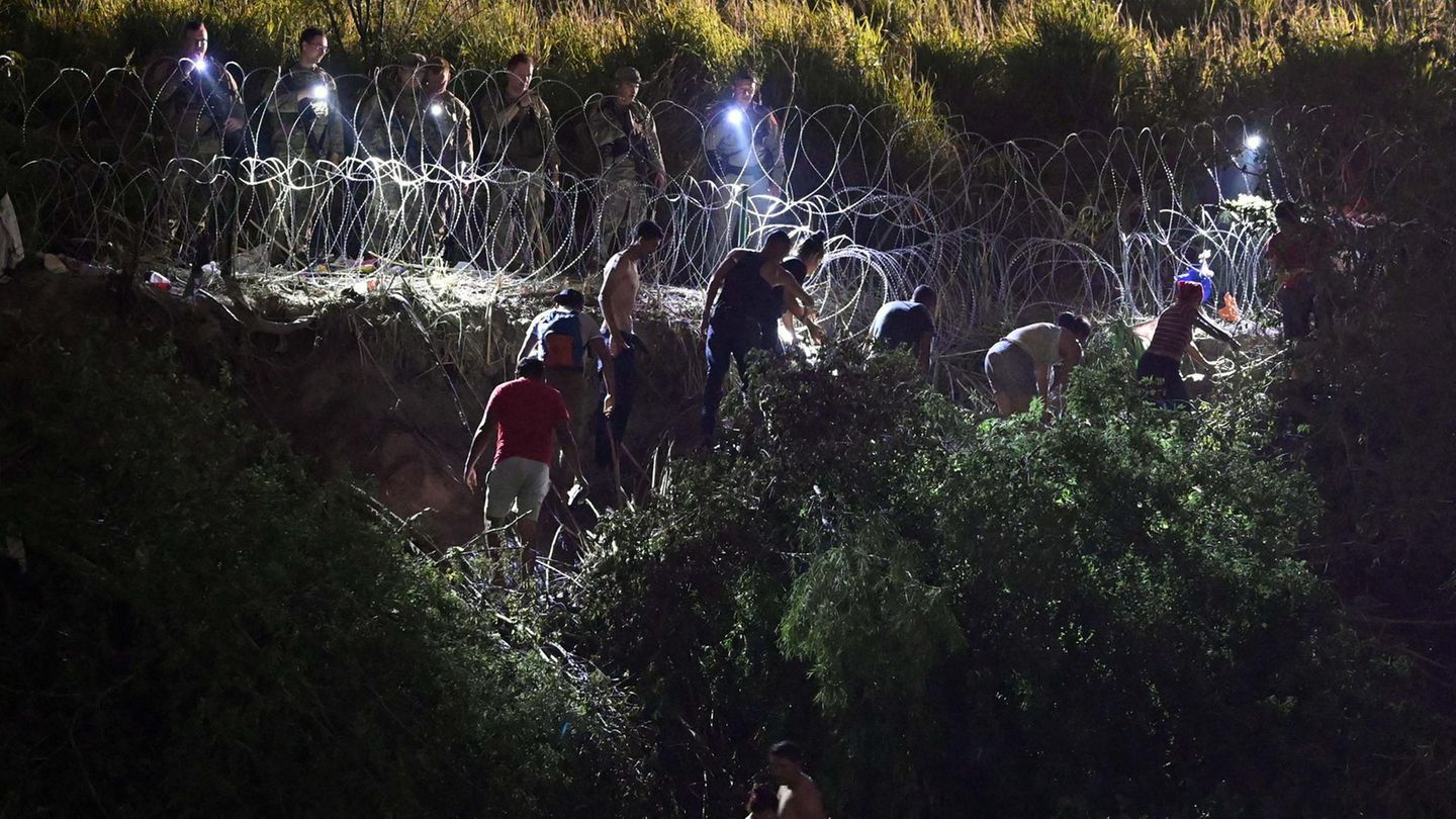 Kurz vor Auslaufen der Titel-42-Regelung in der Nacht zum 12. Mai haben diese Migranten von Matamoros aus den Rio Grande durchquert. Auf der amerikanischen Seite werden sie von Stacheldraht und Grenzschützern mit Taschenlampen empfangen.