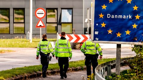Dänische Polizisten laufen an der deutsch/dänischen Grenze auf einem Fußgängerweg